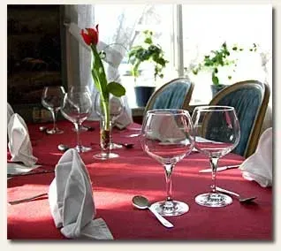 Laid table with wine glasses and a red tulip