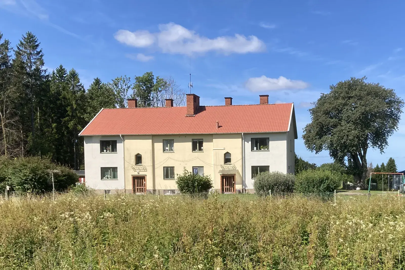 Medelplanagården: a yellow two-storey house with a red tiled roof